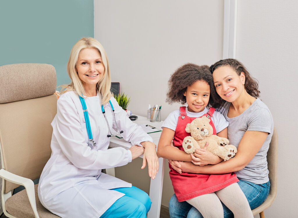 African American girl with her mother and female pediatrician, are sitting in a doctor’s office, smiling and looking at camera. Consultation with child doctor thumbnail