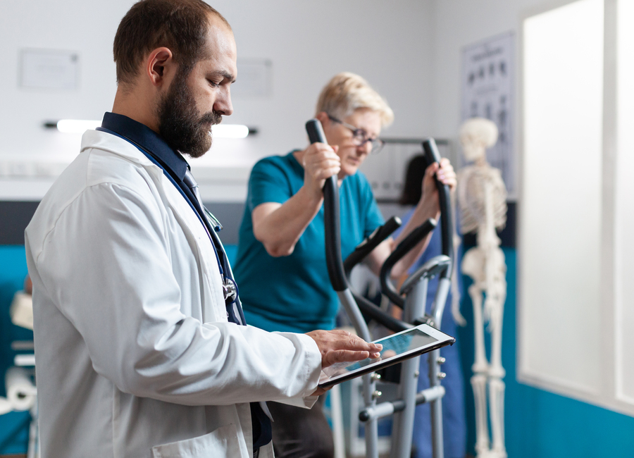 Doctor holding digital tablet for checkup with woman at recovery thumbnail